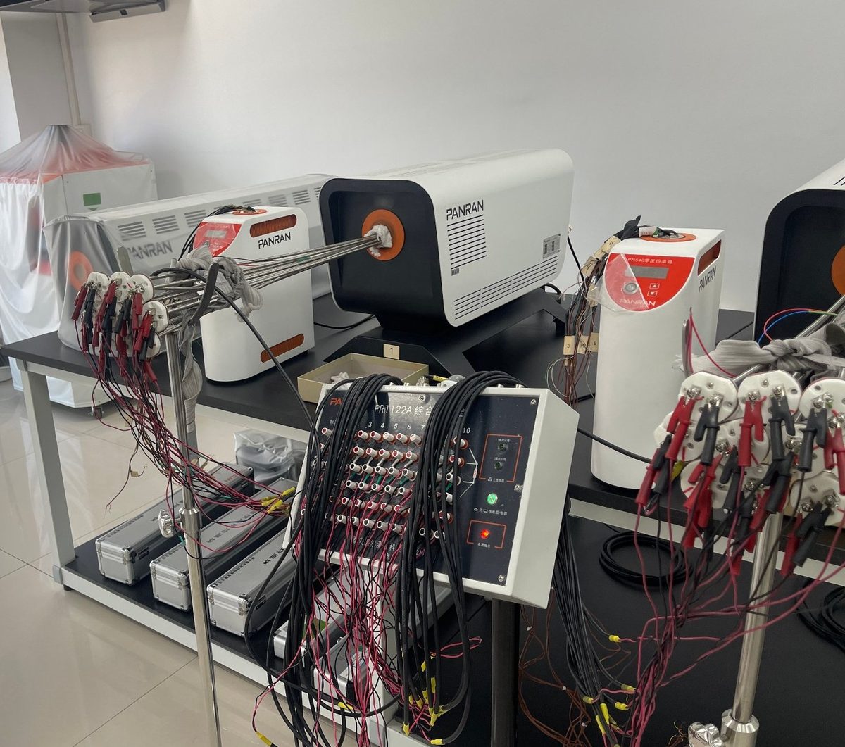 A batch of sheathed thermocouples wired through a multi-channel scanner into reference furnaces for verification